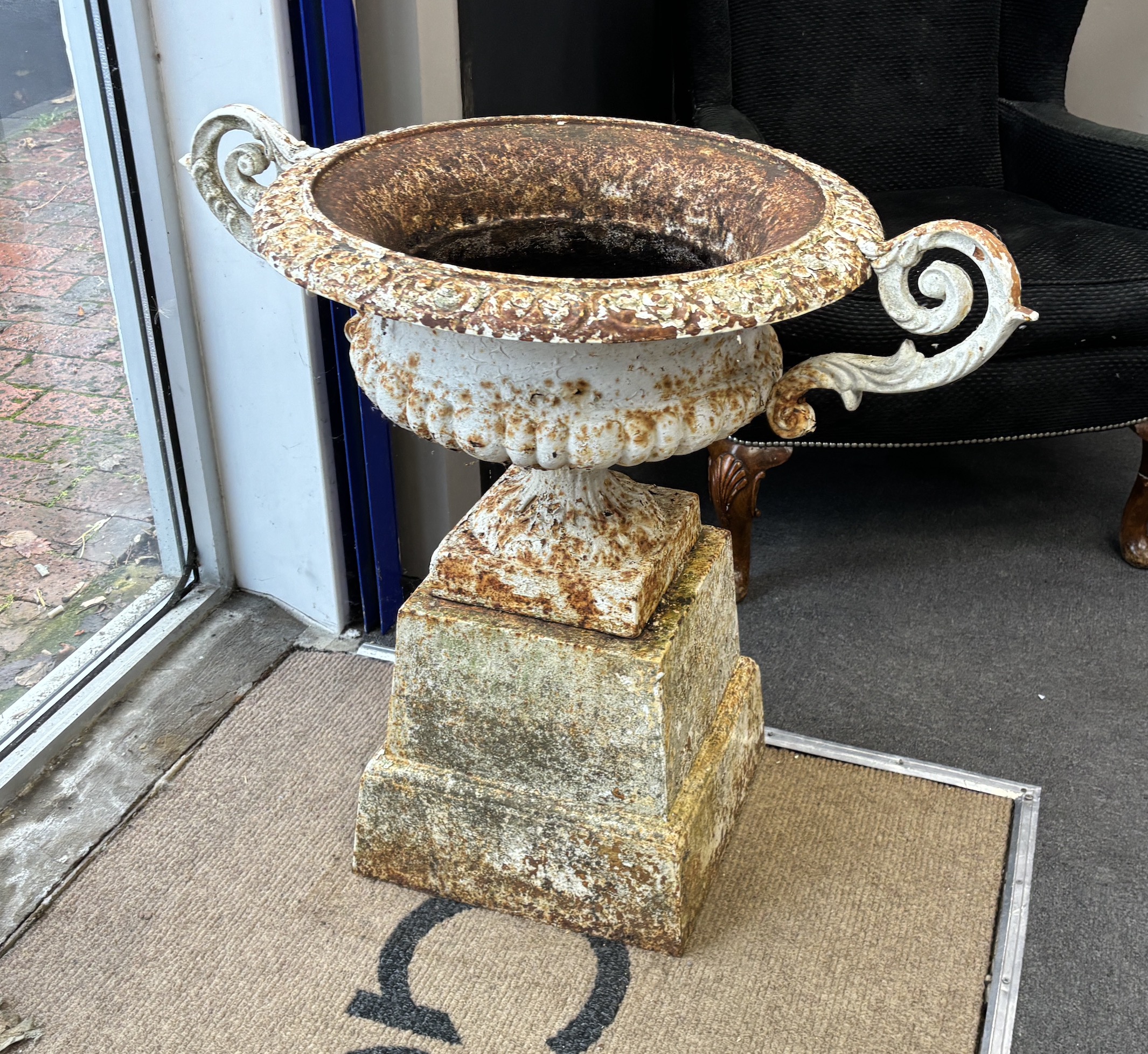 A pair of Victorian circular cast iron campana shaped garden urns, on square cast iron plinths, diameter 60cm, height 80cm